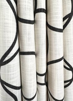 the black and white curtains are lined up against each other, with lines drawn on them