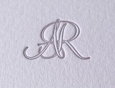 the letter r is made up of paper and thread on top of a piece of white paper