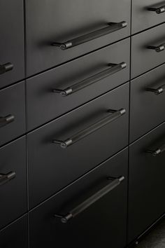 a black cabinet with many drawers and handles