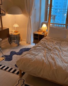 a bed room with a neatly made bed and a night stand next to a window