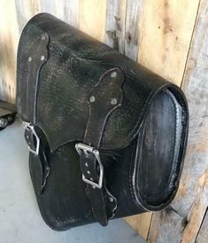 Description 2000-2024 Harley Softail Black Distressed Leather Saddle Bag Bag Fits all 2000-2024 Harley Softails and Many Hardtail Motorcycles By Mother Road Customs MADE IN THE USA Black Distressed Veg Tanned Leather Saddle Bag. This is a Top Quality Leather saddle bag. It fits all 2000 to 2024 Harley Softail models. The entire Bag is made of Heavy Top Grain Veg Tanned Leather. The Sides of the bag are Reinforced with a second layer of leather that help the bag keep it's shape. The bag is attach Black Rectangular Saddle Bag With Gunmetal Hardware, Classic Black Saddle Bag With Gunmetal Hardware, Vintage Black Leather Saddle Bag, Black Leather Saddle Bag Shaped As Satchel, Vintage Black Bags With Leather Backing, Vintage Black Saddle Satchel Bag, Vintage Black Satchel Saddle Bag, Distressed Leather Bag, Motorcycle Black