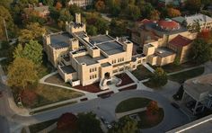 an aerial view of a large building with many windows and trees in the foreground