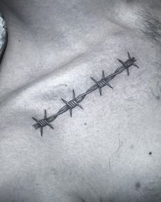 a man's chest with barbed wire tattoo on his left side ribcage