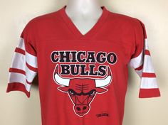 "Vintage 1992 Chicago Bulls jersey style graphic t-shirt. Soft 50/50 cotton polyester by Trench, made in USA. Some cracking in graphics, as shown in the photos. No holes, no stains, no other issues. Size M. Please note measurements to avoid returns: laid flat measures 19.25\" across chest (armpit to armpit), 25.75\" length (top of center of collar on back to bottom of shirt)." Throwback Graphic Print Tops For Football Season, Retro Team Name T-shirt For Streetwear, Retro Fan Gear Tops For Sports Season, Retro Tops For Sports Season Fan Gear, 90s Style Red T-shirt For Sports, Throwback Tops For College Football Season, 90s Style Tops For Game Day During Sports Season, 90s Style Tops For Game Day And Sports Season, 90s Style Tops For Game Day