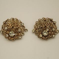 "This is a set of Rhinestone clip earrings. Features a brooch shape and a gold colored design, with a diamond in the center of each earring. Very beautifully detailed/designed. Would make a nice piece of jewelry to wear during the day.  Weight: 5 oz      Size: 1 1/2\" x 1 1'2\" V8840 If you are interested in purchasing more than one item from our shop and/or inquiring about reduced shipping rates--send us your zip code. Also, please contact us for International Shipping Rates." Gold Jeweled Evening Clip-on Earrings, Gold Crystal Jeweled Brooches, Formal Jeweled Metal Clip-on Earrings, Antique Gold Jeweled Earrings, Gold Jeweled Clip-on Earrings For Formal Events, Gold Jeweled Clip-on Earrings For Formal Occasions, Gold Crystal Brooch For Evening, Gold Brooches With Rhinestones For Evening, Crystal Clip-on Earrings For Evening