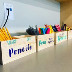 pencils and pens are lined up in wooden boxes