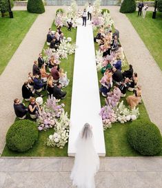 a bride and groom walking down the aisle to their wedding ceremony in an elegant garden