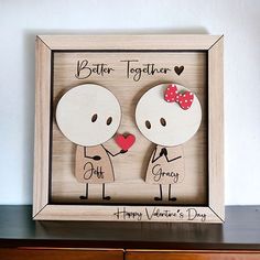 a couple is holding hands in a wooden frame with the words happy valentine's day written on it