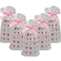 four bags with hearts on them and pink ribbon tied around the top one bag has a bow at the bottom