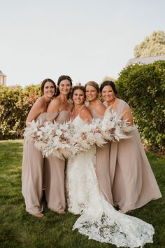 the bride and her bridesmaids pose for a photo in their wedding gowns