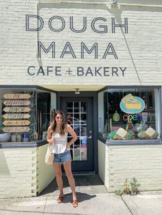 a woman standing in front of a doughnut shop