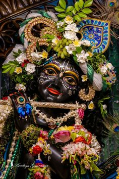 an idol is adorned with flowers and leaves