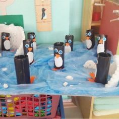 a group of penguins made out of toilet paper rolls sitting on top of a table