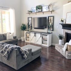 a living room filled with furniture and a flat screen tv mounted on a wall above a fireplace