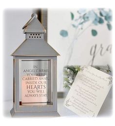 a small metal lantern with a note attached to it and a card next to it