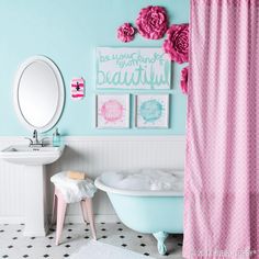 a bathroom decorated in pink and blue with flowers on the shower curtain, sink, and bathtub