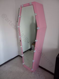 a large pink mirror sitting in the corner of a room