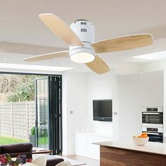 a ceiling fan in the middle of a living room with white walls and wood floors