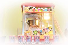 an old fashioned popcorn machine with pictures on it