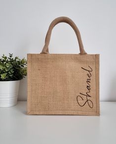 a jute bag with the word welcome on it and a potted plant next to it