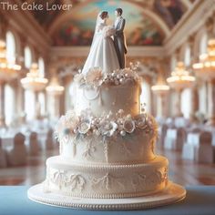 a wedding cake with white frosting and flowers on the top is in front of an ornately decorated ceiling