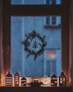 a window sill filled with christmas decorations next to a wreath on top of a window