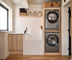 a washer and dryer in a room with wood flooring on the walls