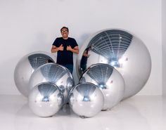 a man standing in front of some shiny balls