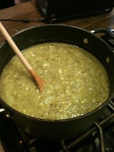 a pot filled with green liquid sitting on top of a stove