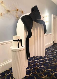 a large black bow on top of a white radiator next to a trash can