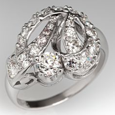 This lovely circa 1950s ring features a ribbon design and is accented with one (1) old European cut diamond set into a four-prong head and twenty-three (23), bead set, round brilliant/single cut diamonds. The ring measures 15.3mm at the top, rises 7.9mm above the finger, tapering to 2.0mm wide and 0.9mm thick at the base of the shank. This ring is currently a size 8. Art Deco Diamond Cluster Ring With 17 Jewels, Elegant Diamond White Ring With 17 Jewels, Vintage Single Cut Diamond Ring For Formal Occasions, Vintage Single Cut Diamond Ring For Formal Events, Art Deco Diamond Ring With Accents For Vintage Events, Art Deco Formal Cluster Ring With Center Stone, Estate Platinum Jewelry With Center Stone, Estate Style Platinum Jewelry With Center Stone, Estate Diamond Cut Diamond Rings