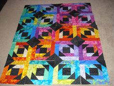 a multicolored quilt is laying on the floor