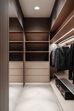 an empty walk in closet with clothes hanging on shelves