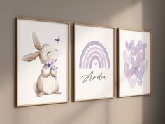 three framed art prints on the wall in a child's room, each with an animal and rainbow theme