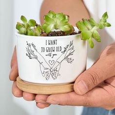 a person holding a potted plant with the words i want to grow old on it