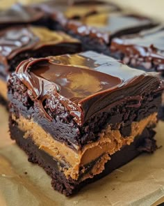 two pieces of brownie with chocolate frosting on top and one piece cut in half