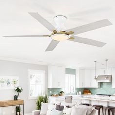 a living room filled with furniture and a ceiling fan in the middle of a kitchen