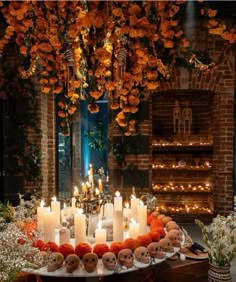 a table topped with lots of candles and skulls on top of plates next to flowers