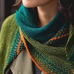 a woman wearing a green and orange knitted scarf