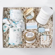 an open gift box filled with items from the body and hand care brand, such as creams, candles, scrubs, and more