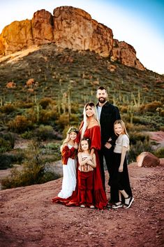 a family poses for a photo in front of a mountain with cacti and cactus