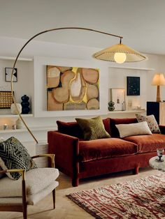 a living room filled with lots of furniture next to a fire place and a painting on the wall