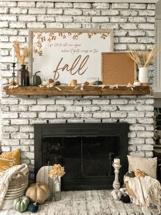 a white brick fireplace with fall decorations on it and a sign above the fire place