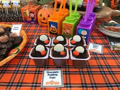 a table topped with cupcakes and halloween treats