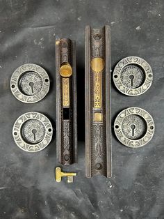 an assortment of door handles and knobs on a black surface with one keyhole open