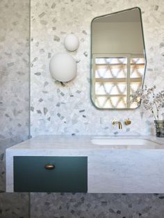 a bathroom with marble counter top and two sinks in front of a wall mounted mirror