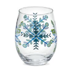 a glass with a snowflake design on the bottom and green leaves around it