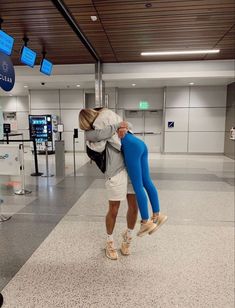 two people hugging each other in an airport