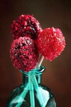 two red carnations in a green glass vase