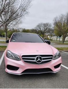 a pink mercedes benz parked in a parking lot